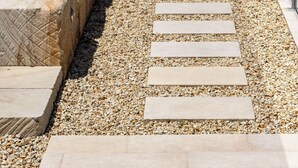 A pathway with stone steps leading to a grassy area.