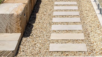 A pathway with stone steps leading to a grassy area.