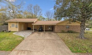 A single-story house with a covered garage and a front yard.