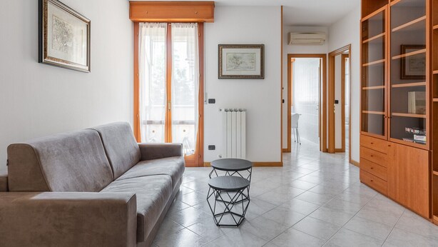 Una sala de estar con un sofá, una mesa redonda y un aparador de madera.
