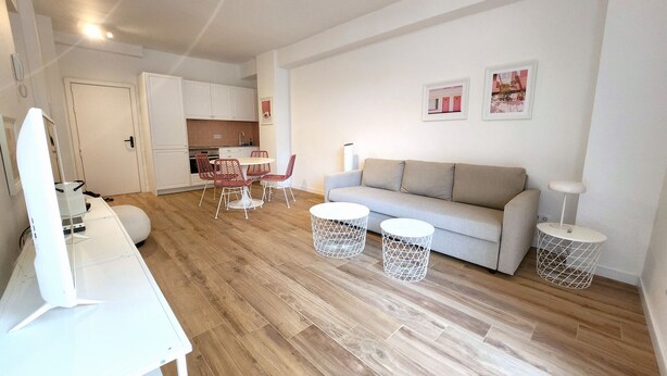 A modern living room with a sofa, coffee table, and chairs, a kitchen in the background, and a dining area with a table and chairs. - Pink Alta Apartment With Pool (Puerto de la Cruz)