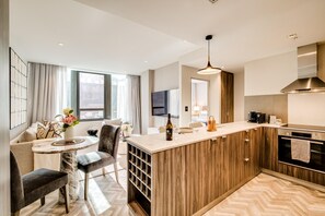 A modern kitchen with wooden cabinets, a marble countertop, and a built-in wine cooler. - Cape Town Central 1bed Apartment City Suite 1006 (Cape Town)