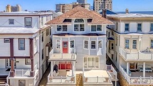 Un immeuble à plusieurs étages doté d’une baie vitrée, d’une porte rouge et d’un balcon.