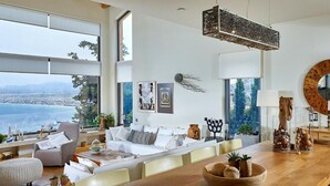 A spacious living area with a large wooden dining table, a comfortable sofa set, and a view of the sea. - Villa Vollard Panoramic Seaview Private Pool (Malevizi)