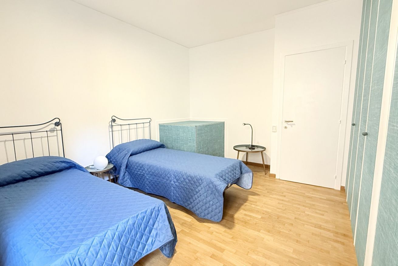 Una habitación con dos camas, una mesita redonda y una puerta.