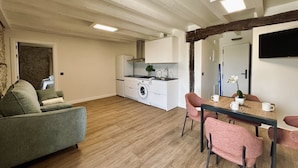 A modern apartment with a living area, kitchen, and dining space. - Casa De Postas - Duplex Superior (San Miguel de Meruelo)