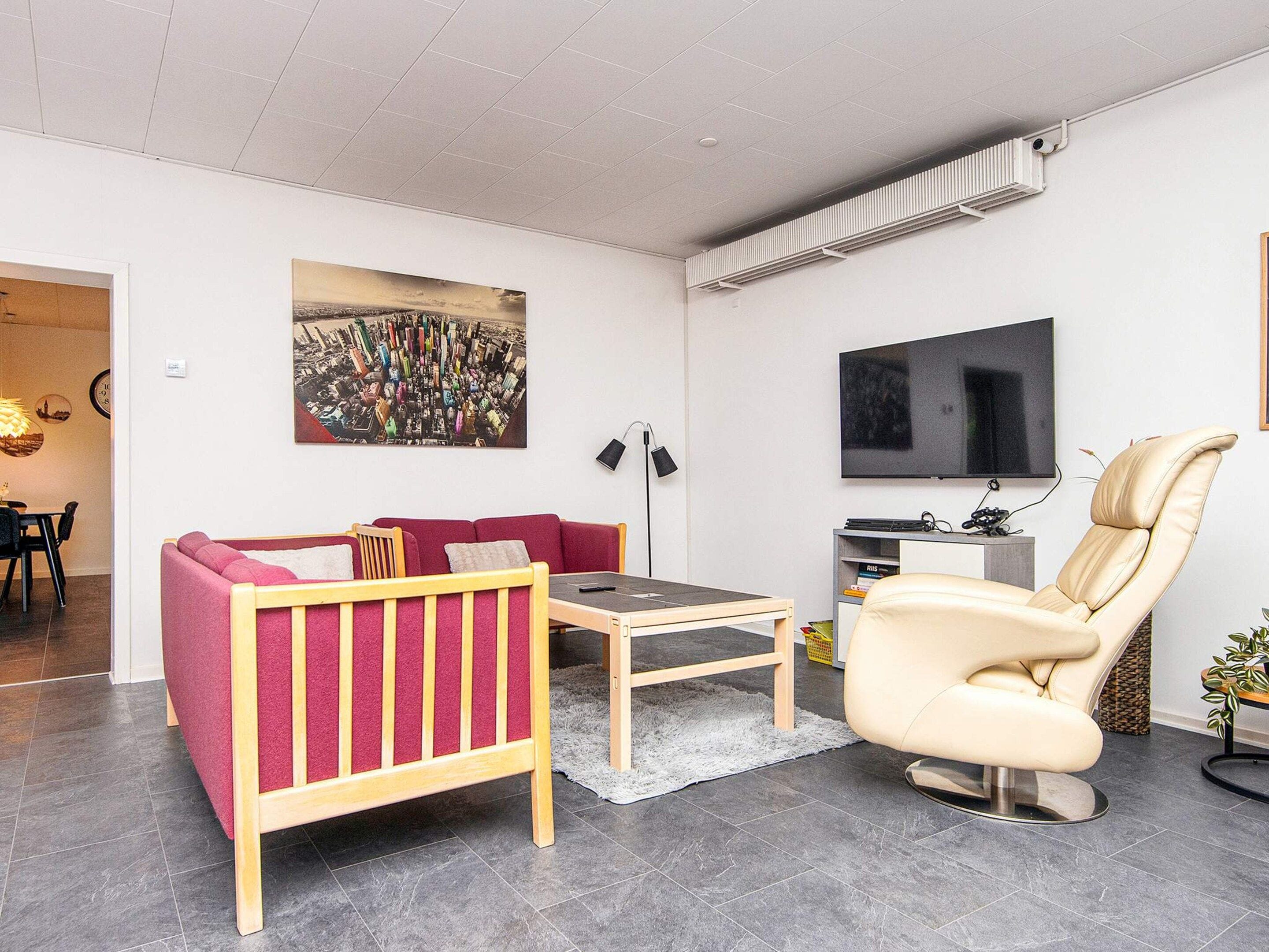 A modern living room with a sofa, a coffee table, a TV, and a chair.