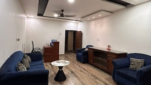Een moderne woonkamer met twee blauwe banken, een salontafel en een tv-meubel.