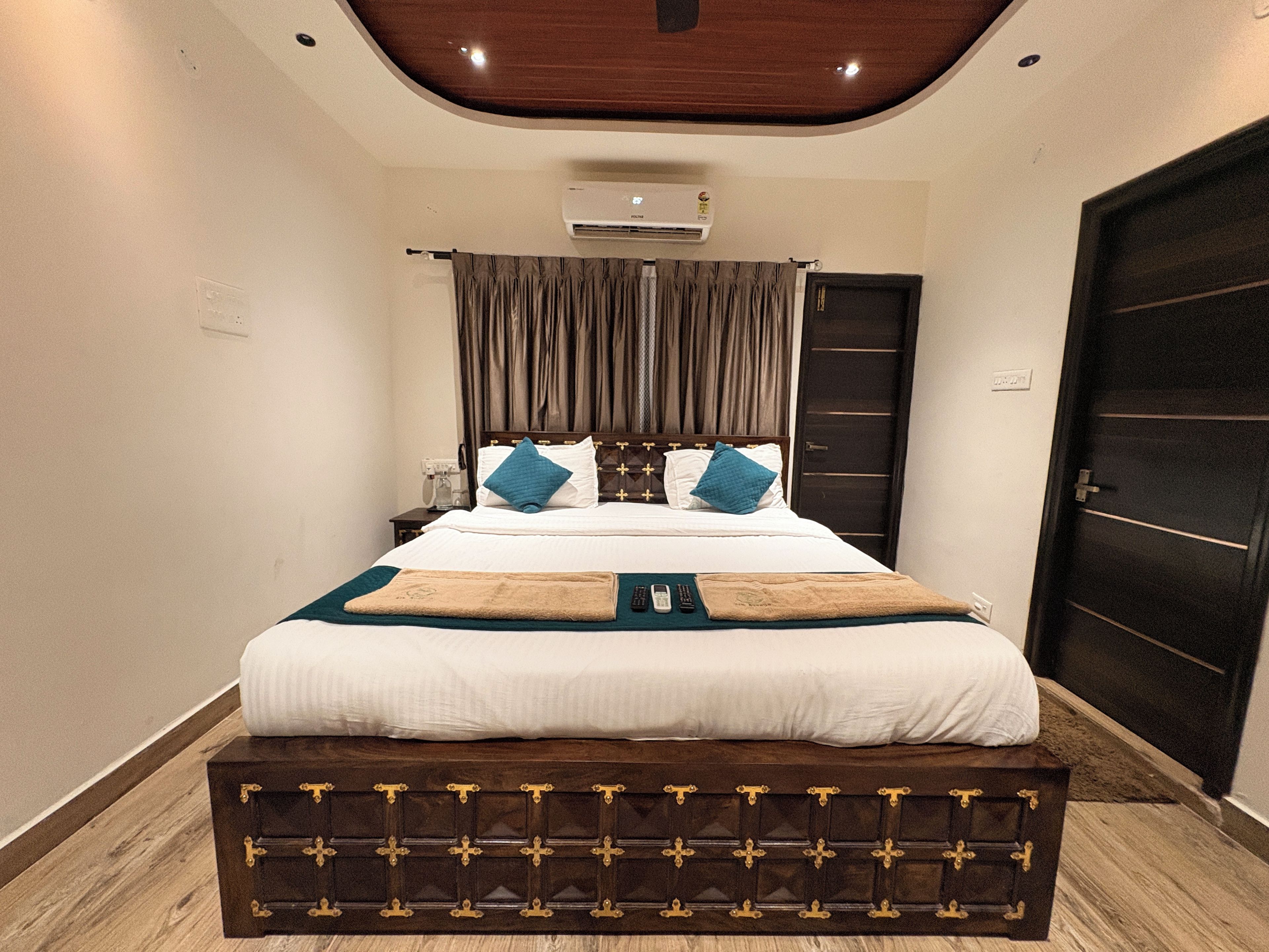 Une chambre d’hôtel comprenant un lit, une table de chevet, une commode, une armoire et un appareil de climatisation.