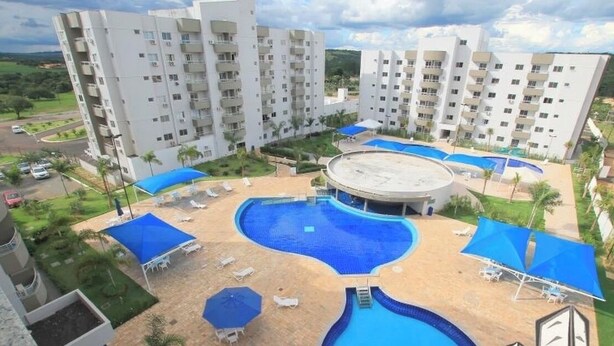 A hotel with multiple buildings, a central swimming pool, and outdoor seating areas. - 1 bedroom apartment in Lagoa Quente flat service (Caldas novas)