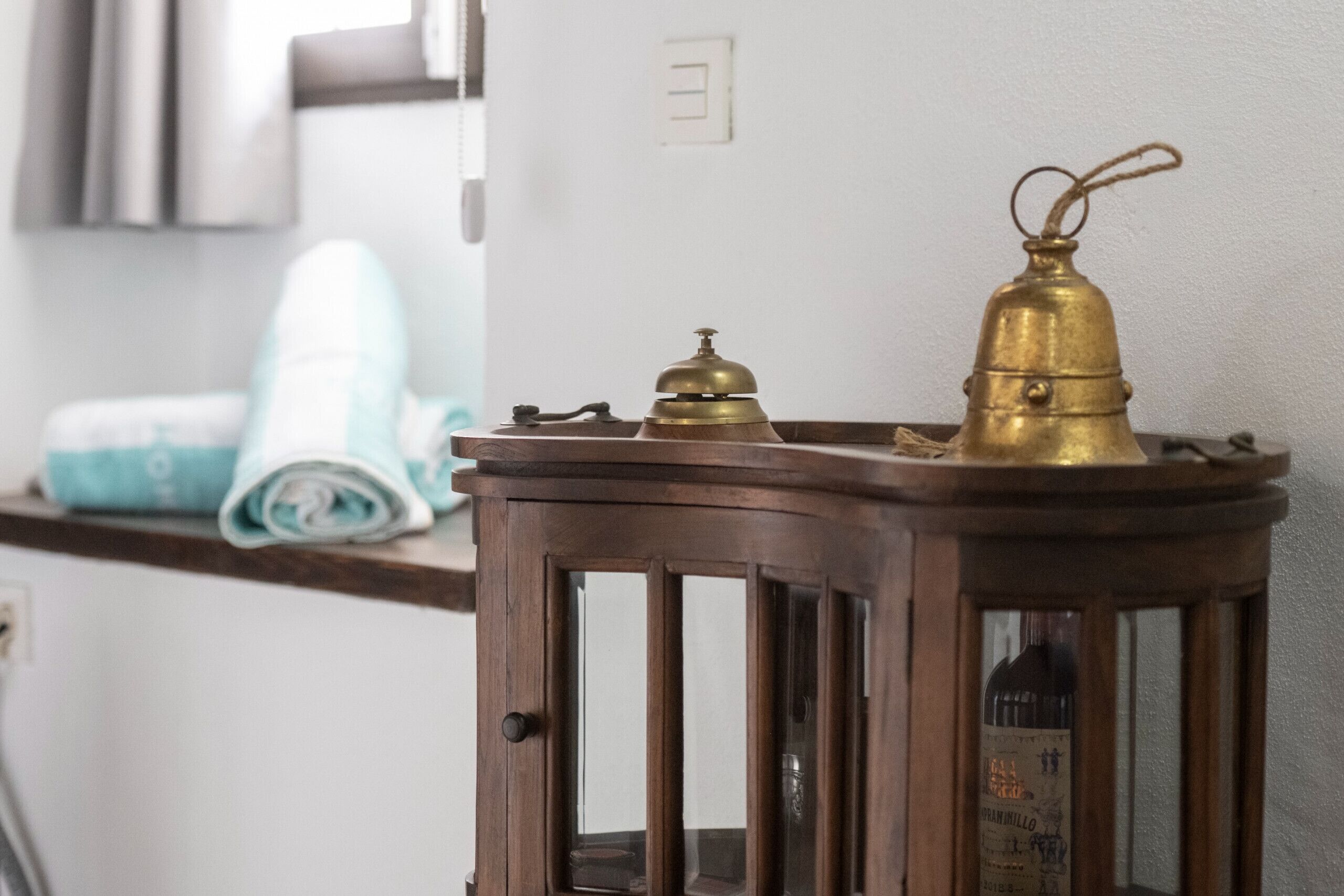 A wooden lantern with a brass top and a bottle label visible through the glass.