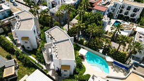 Vista aérea de um bairro residencial com edifícios modernos, piscina e palmeiras.