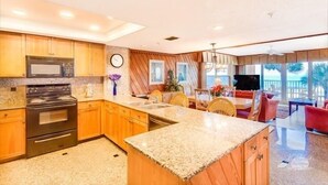 A modern kitchen with granite countertops, wooden cabinets, and a central island.