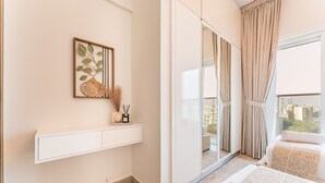 A modern bedroom with a large window, a bedside table, a bed, and a sliding door leading to a balcony.