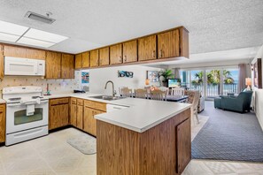 Una cocina moderna con armarios de madera, una estufa blanca y una isla grande.