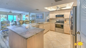 A spacious kitchen with granite countertops, stainless steel appliances, and a large island.