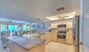 Una cocina amplia con encimeras de granito, electrodomésticos de acero inoxidable y una isla grande.