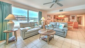 A living room with two sofas, a coffee table, and a dining area with chairs.