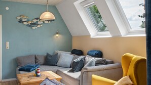 Een gezellige woonkamer met een bank, een bijzettafeltje en een lamp.