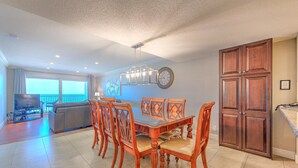 Amplia sala de estar con mesa de comedor, sillas, sofá y televisor.