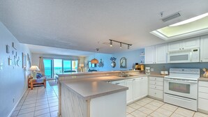 Una cocina moderna con armarios blancos, una isla grande y un horno empotrado.