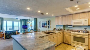 Una cocina amplia con una isla grande, armarios de madera, un microondas y un horno.