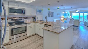 Una cocina moderna con electrodomésticos integrados, una isla central y un comedor con vistas.