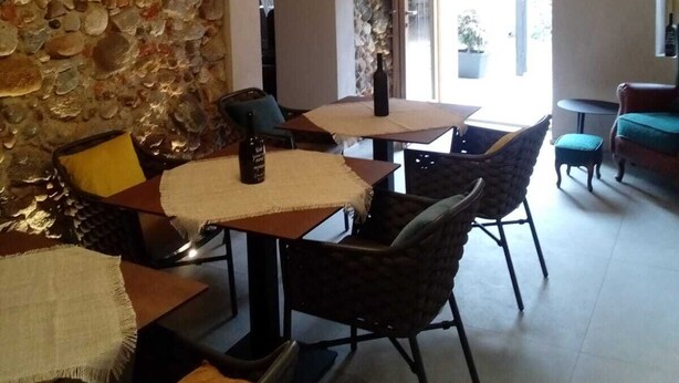 Un comedor con paredes de piedra, una araña y vistas al exterior.