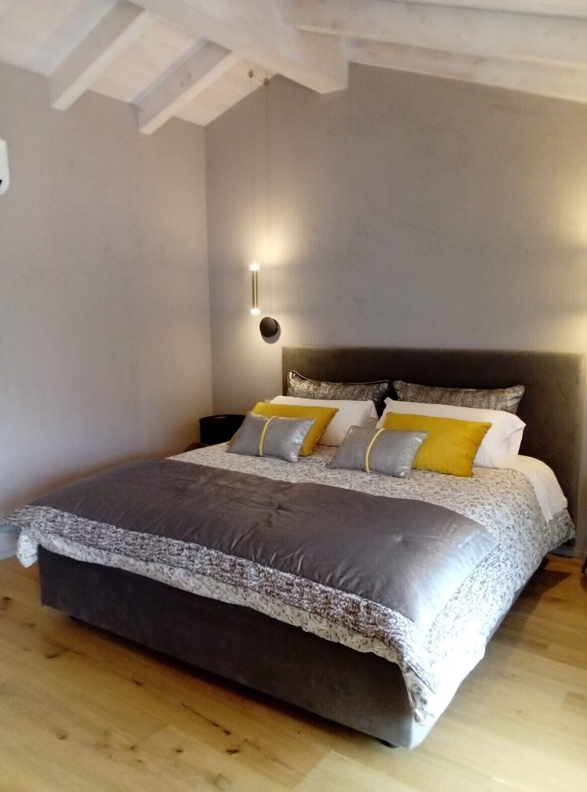 Camera da letto con un letto grande, una testiera e un lampadario a parete.