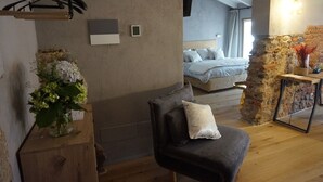Una habitación moderna con una cama, una silla, una mesa de madera y un jarrón de flores.