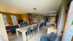 Un espacio moderno con comedor, cocina y un área de descanso acogedora.