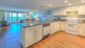 A spacious kitchen with white cabinetry, a central island, and a large island with seating.
