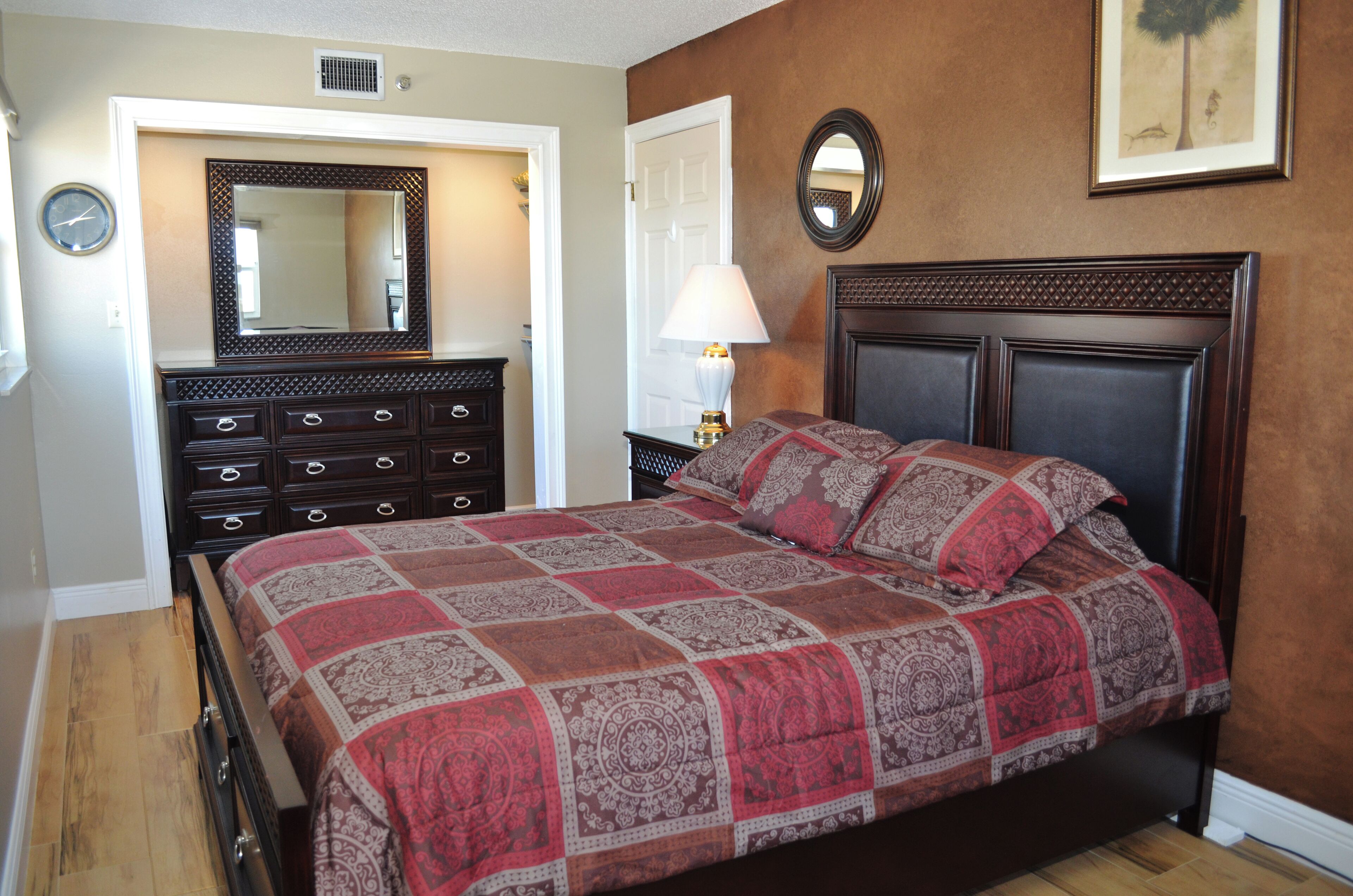 Un dormitorio con cama, cómoda y espejo.
