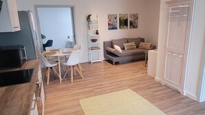 A modern kitchen with a dining area, a sofa, and a large rug. - Apartment 'Rike' with Shared Terrace, Shared Garden and Wi-Fi (Oesterdeichstrich)