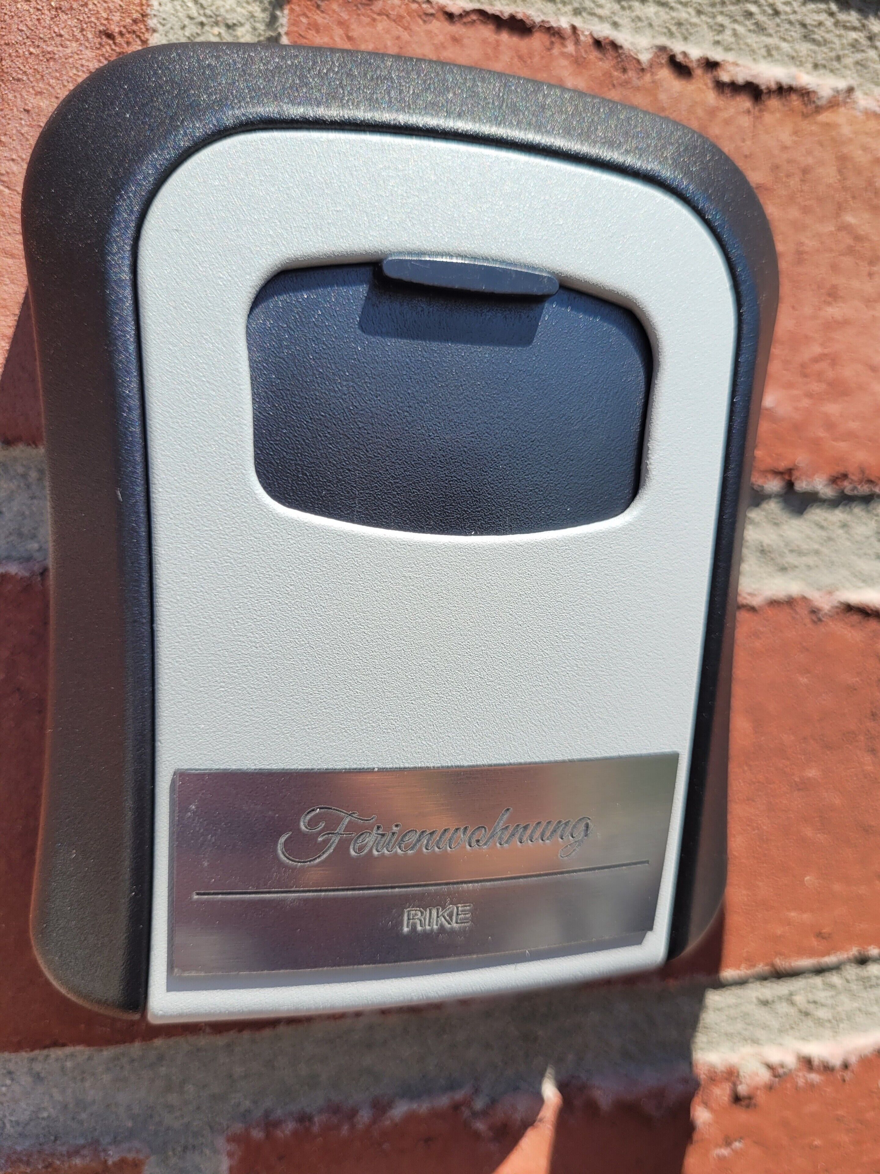 A metal device with a rectangular shape, a black top, and a silver bottom with embossed text.