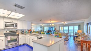 Una cocina amplia con electrodomésticos modernos, una isla grande y vistas al área de estar.