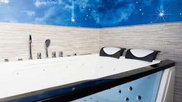 Un bagno moderno con un murale raffigurante un cielo stellato, una vasca da bagno grande e un pavimento in legno.