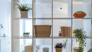 A modern interior with a white shelving unit displaying various items.