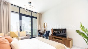 A modern hotel room with a large bed, a television, a desk, and a view of the city through large windows. - Bloomfields Fabulous STU In Al Maryah (Abu Dabi)