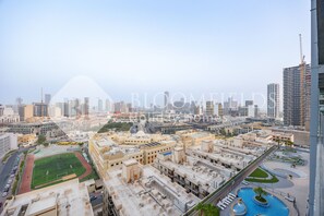 A cityscape with a large sports field, multiple buildings, and a swimming pool.