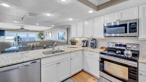 A modern kitchen with white cabinets, a Bosch dishwasher, a stainless steel microwave, and a gas stove. - Huge 3rd Floor Gulf Front Condo w/ Balcony SD304 (Indian Shores)