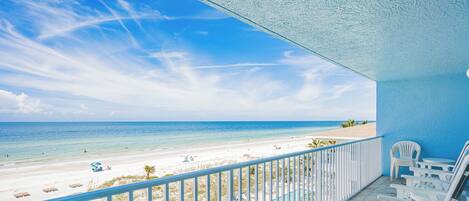 Ein Balkon mit Blick auf Strand und Meer.