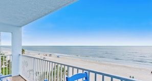 Ein Balkon mit Blick auf Strand und Meer.
