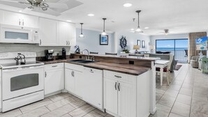 Una cocina moderna con armarios blancos, horno integrado y una isla de madera.