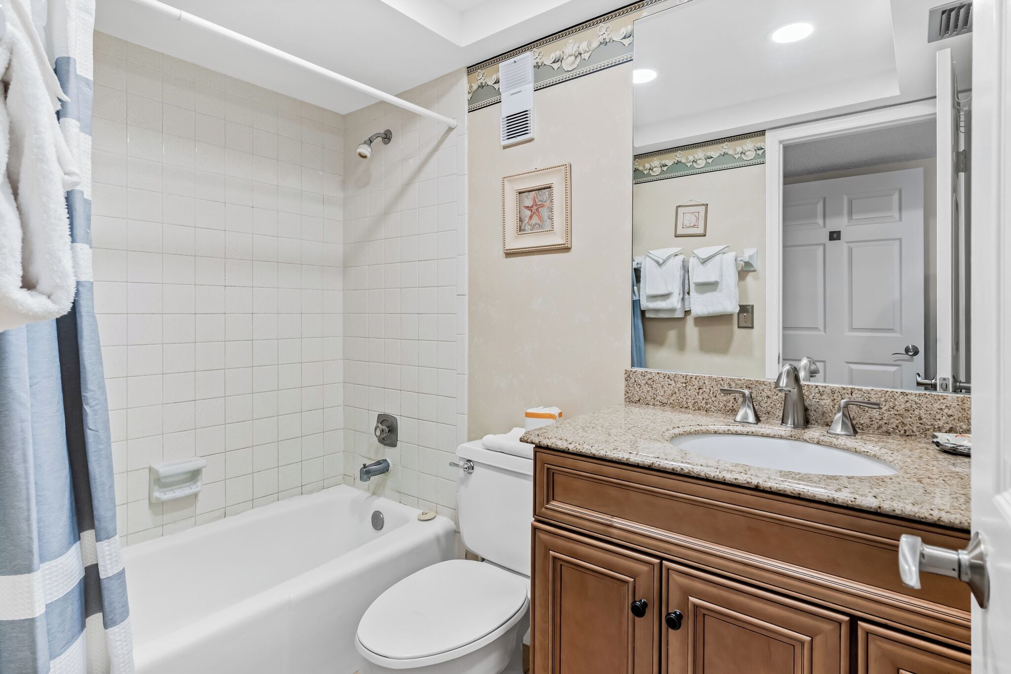 Een badkamer met een bad, toilet, wastafel en badkamermeubel.