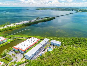 A large hotel with multiple buildings, a swimming pool, and a dock extending into a body of water.