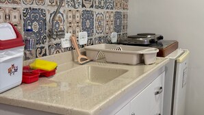 A kitchen with a sink, a stove, and a refrigerator.