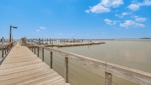 A wooden pier extending into calm water with a clear sky. - Resort Condo w/ Marina Access in Williamsburg! (Williamsburg)
