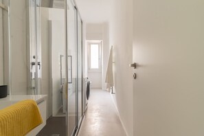 A modern bathroom with a glass shower enclosure, a white sink, and a yellow towel. - w Stylish 2BR Near Navigli City Landmarks (Milan)