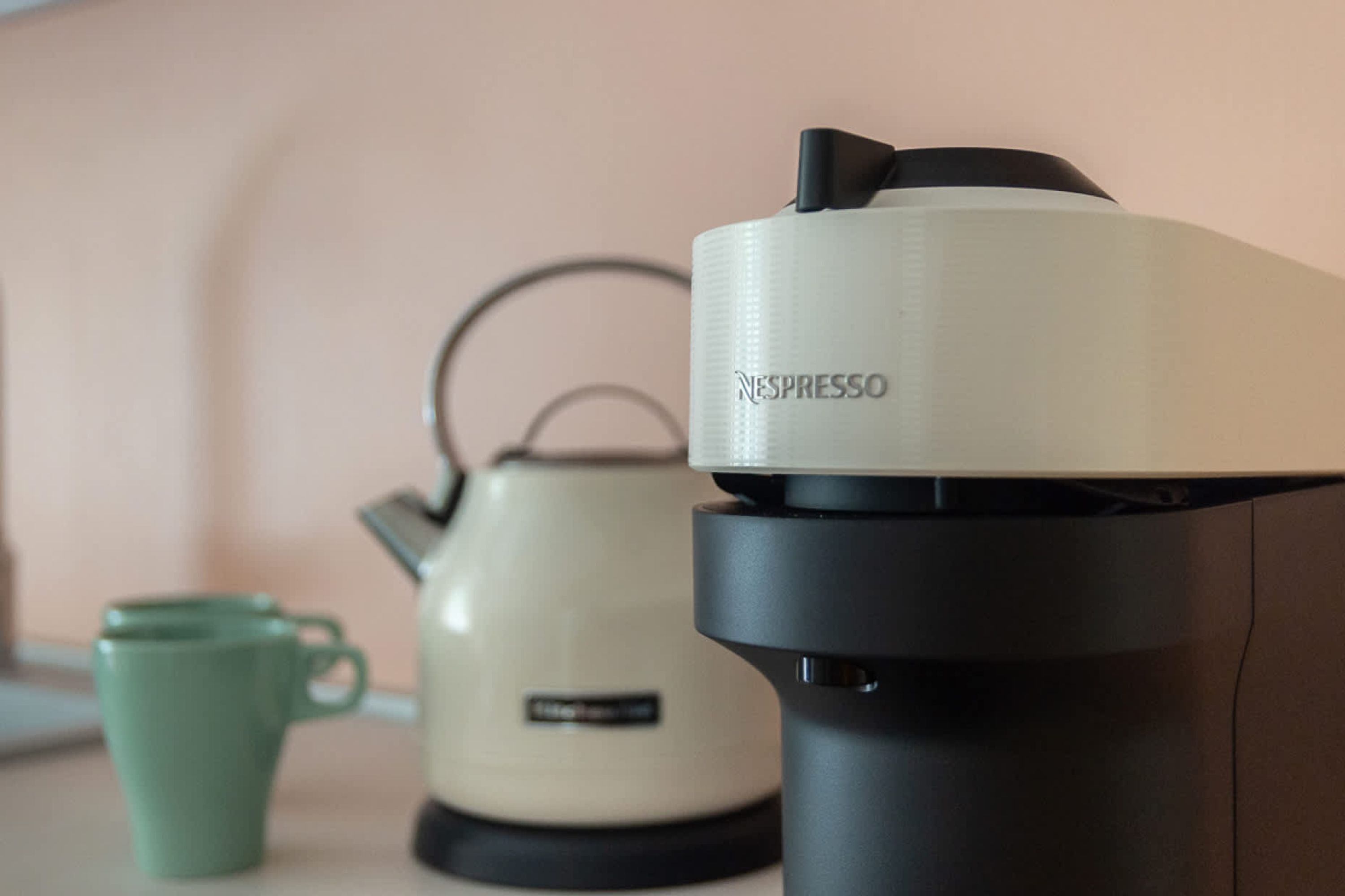 Une machine à café Nespresso et une bouilloire sur un plan de travail.